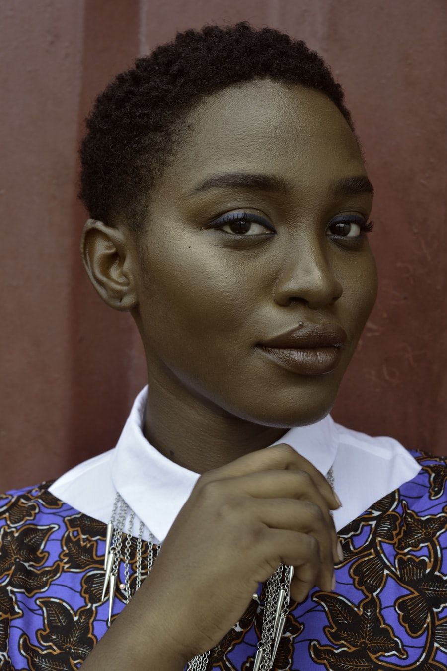 Portrait of a woman in a white collar and printed top, in warm light